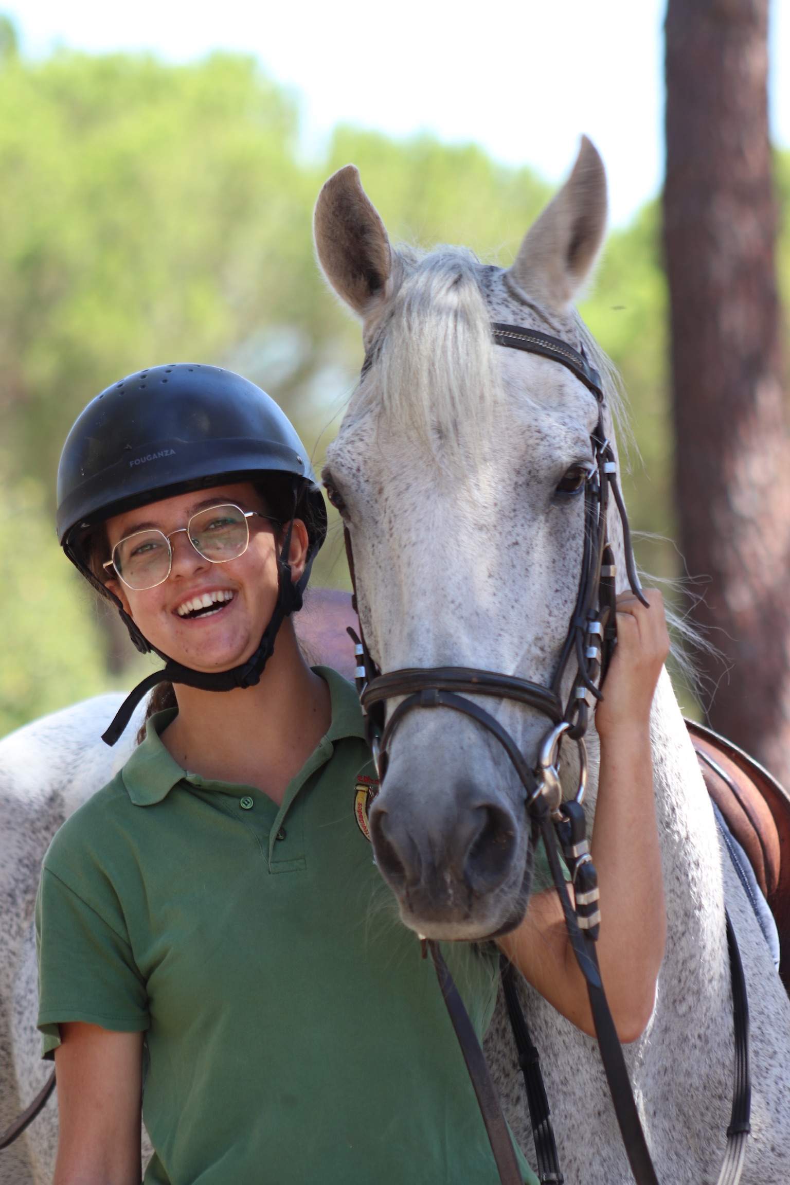 Katie Bailey riding a horse in a field during sunset