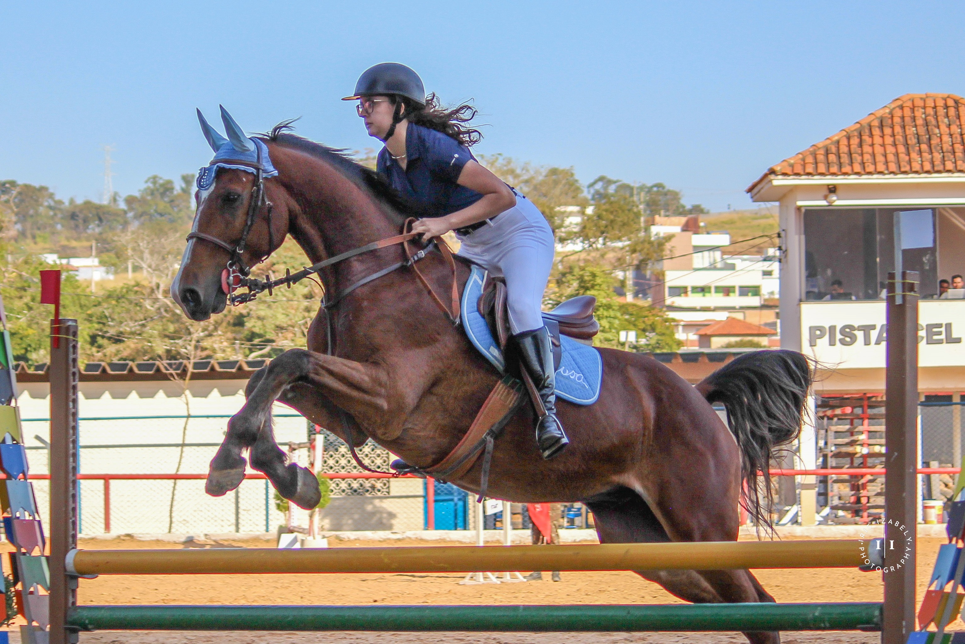 A rider on a white horse in a dressage competition arena